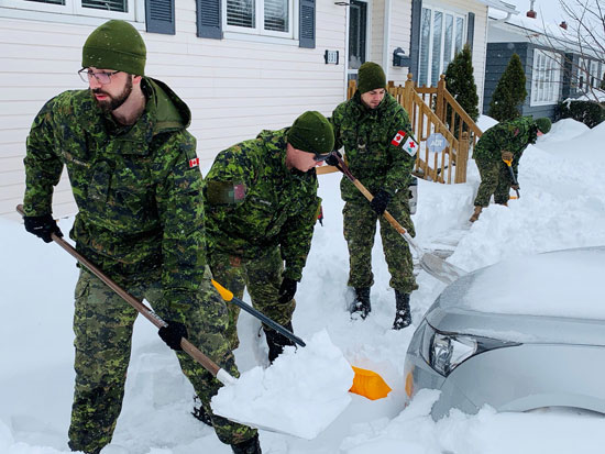 أعضاء القوات الكندية يساعدون السكان في إزالة الثلوج في سانت جونز