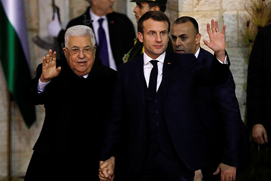 الرئيس ماكرون والرئيس عباس يلوحون وهم يرفعون أيديهم في رام الله