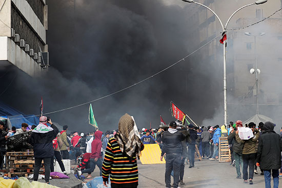 تصاعد الدخان جراء إشعال النيران فى خيم المحتجين فى بغداد