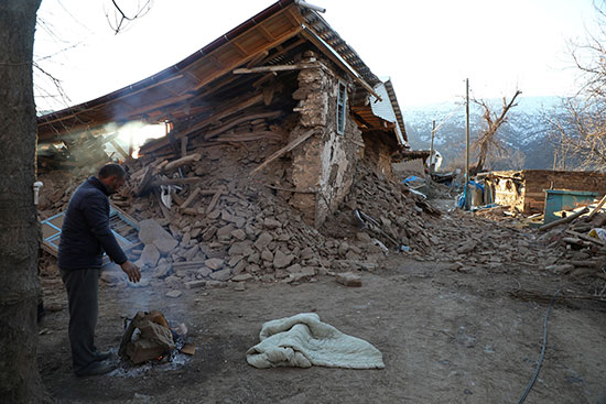 مواطن تركى يتفقد آثار الدمار الذى لحق بمنزله بعد الزلزال