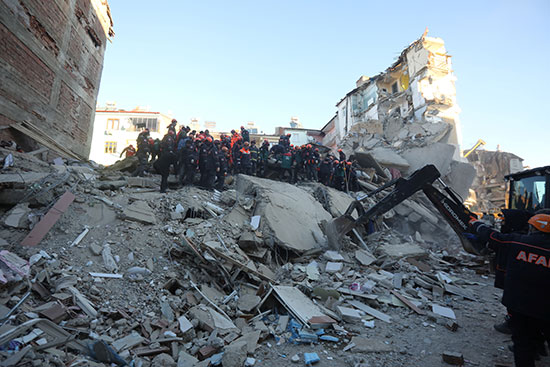 عمال الانقاذ يعملون في مبنى انهار بعد زلزال في العزيج فى تركيا