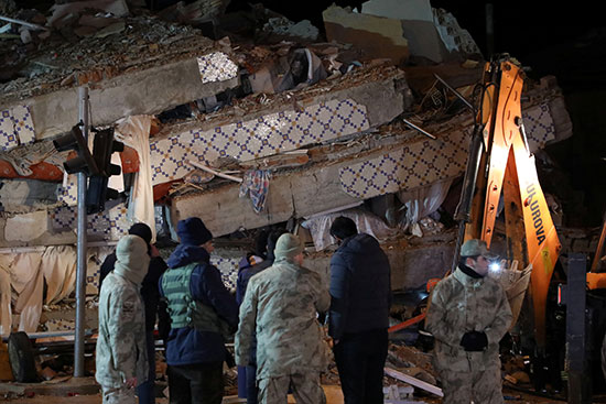 قوات الأمن التركية تقف حراسة خارج مبنى انهار بعد زلزال في العزيج