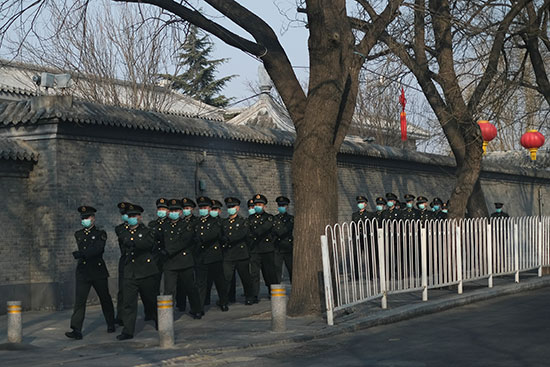 جنود-جيش-التحرير-الشعبي-الصيني-يرتدون-أقنعة-واقية-يسيرون-على-طول-شارع-في-بكين