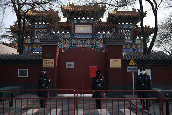 يقف-ضباط-الشرطة-في-حراسة-أمام-بوابة-معبد-لاما-المغلقة