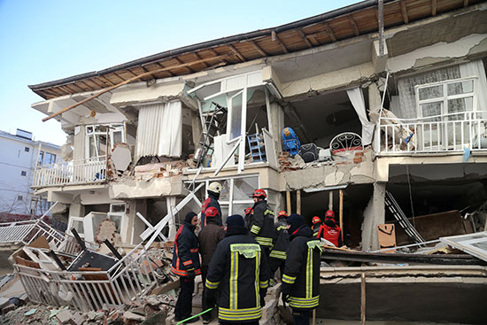 عمال الانقاذ يعملون على مبنى تالف بعد زلزال في العزيج
