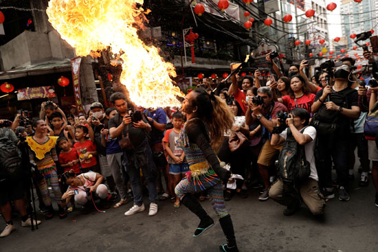 مشاهدة رجل ينفخ النار خلال احتفالات السنة القمرية الصينية الجديدة