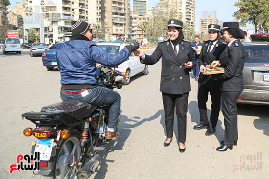 الشرطة النسائية توزع الحلوى على المواطنين