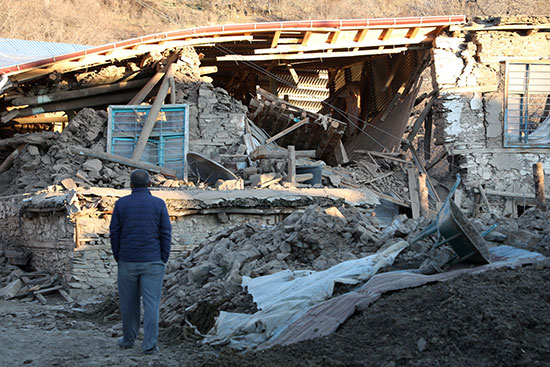 مواطن تركى ينظر إلى منزله المنهار بعد الزلزال