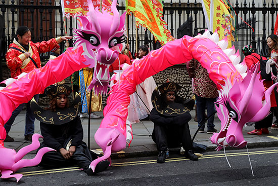الممثلون يأخذون استراحة قبل المشاركة في عرض السنة القمرية الصينية الجديدة وسط لندن