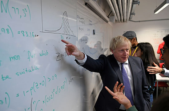 يتفاعل رئيس الوزراء البريطاني بوريس جونسون أثناء استماعه للطلاب