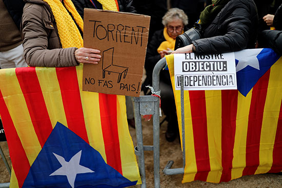 أحد المتظاهرين يحمل لافتة كتب عليها هدفنا الاستقلال خلال احتجاج خارج البرلمان الإقليمي في برشلونة