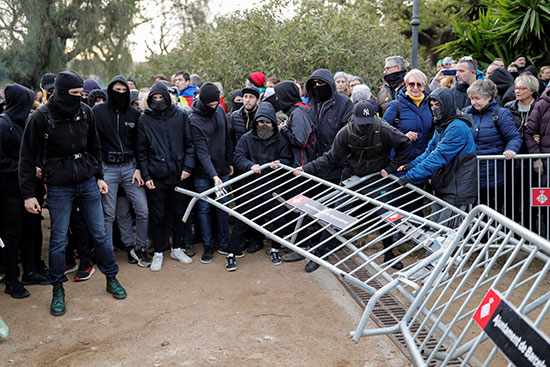 المتظاهرون يحملون سورًا معدنيًا أثناء احتجاج خارج البرلمان الإقليمي في برشلونة