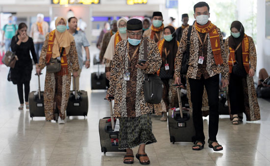 أشخاص يرتدون أقنعة يمشون في مطار باندارانايكي الدولي