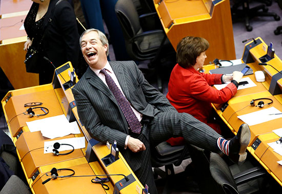 زعيم حزب Brexit Nigel Farage يبتسم وهو يظهر جواربه خلال جلسة عامة في البرلمان الأوروبي