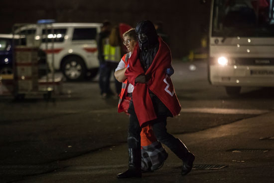 سيدة من الصليب الأحمر تحتضن أحد المهاجرين