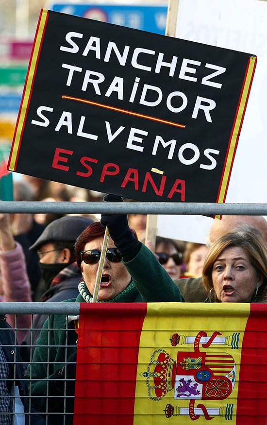 يحمل المتظاهرون لافتة أثناء مظاهرة خارج البرلمان الكتالونى حيث تجري مناظرة حول الاستثمار