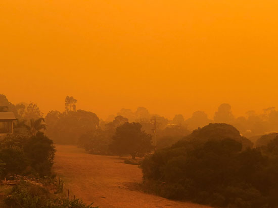 السماء تضيء باللون البرتقالى نتيجة حرائق الغابات المحيطة بالقرب من بلدة مالاكوت