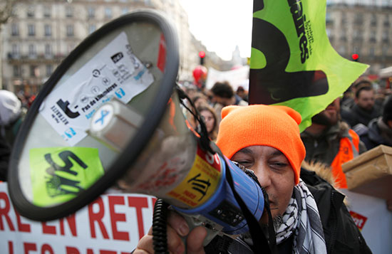 متظاهر يحمل مكبرًا صوتيًا في مظاهرة خلال اليوم الحادي والثلاثين على التوالي من الإضراب