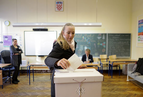 فتاة-أوكرانية-تضع-صوتها-بصندوق-الاقتراع