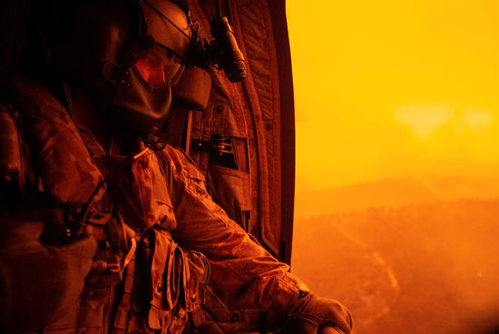 أحد الجنود من داخل طائرة الأطفاء يرصد حرائق الغابات فى أستراليا