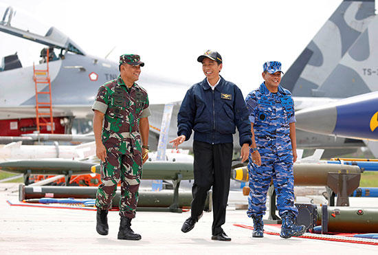 الرئيس الإندونيسي جوكو ويدودو يسير عبر الطائرات المقاتلة والأسلحة خلال مناورة عسكرية