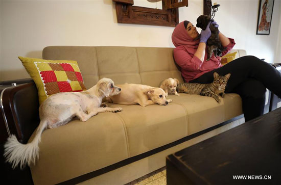 مها منصور مع القطط والكلاب التي ترعاها