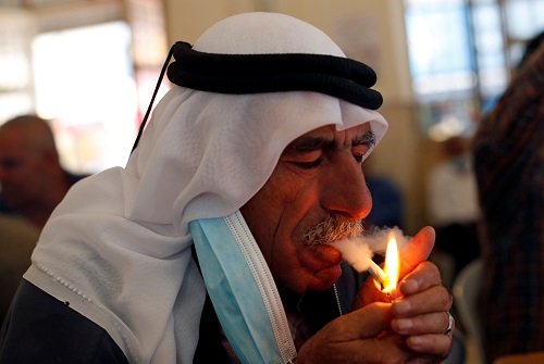 فلسطيني يدخن سيجارة في مقهى بالضفة الغربية