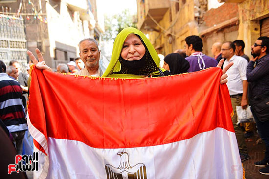 ناخبة-ترفع-علم-مصر-قبل-الادلاء-بصوتها-في-الانتخابات-البرلمانية