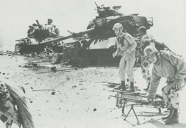 رجال الجيش المصرى وخلفهم دبابات إسرائيلية مدمرة فى حرب اكتوبر عام 1973