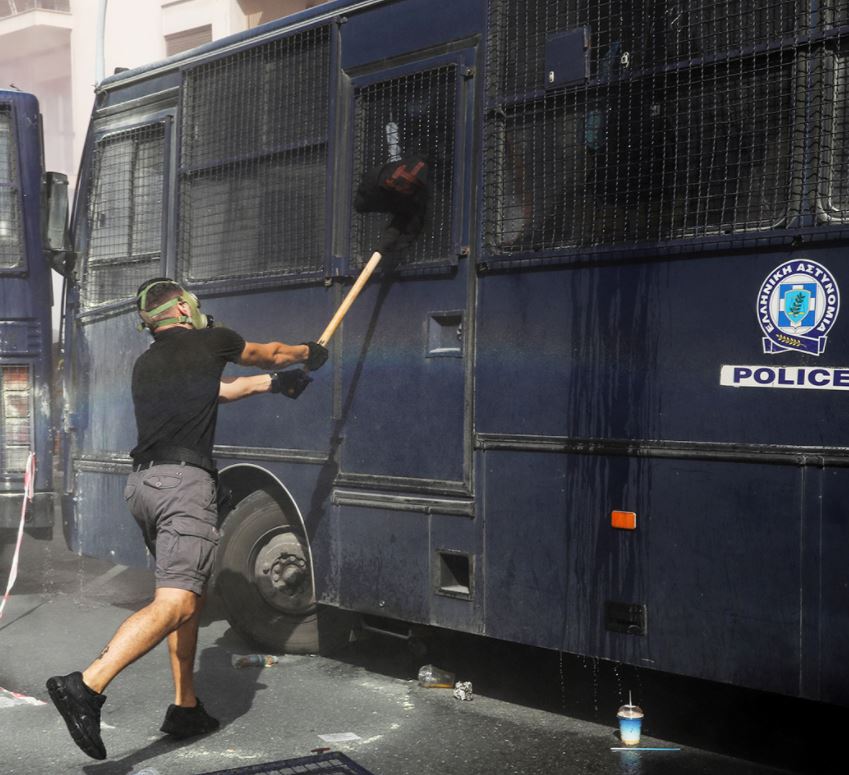 متظاهر يعتدي على سيارة شرطة في اليونان