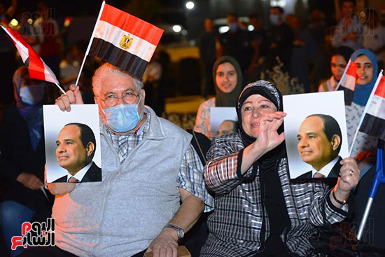 رجل وزوجته يرفعان صورة الرئيس السيسى وعلم مصر