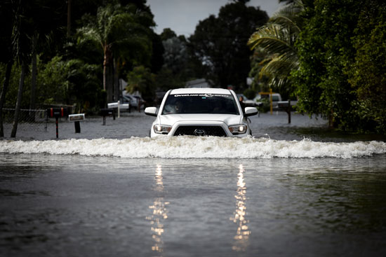 ركاب يقود سيارته في مياه فيضانات سببتها العاصفة إيتا في ديفي