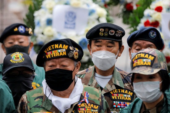 يرتدي الجنود الكمامات أثناء حضورهم حدث وضع إكليل من الزهور