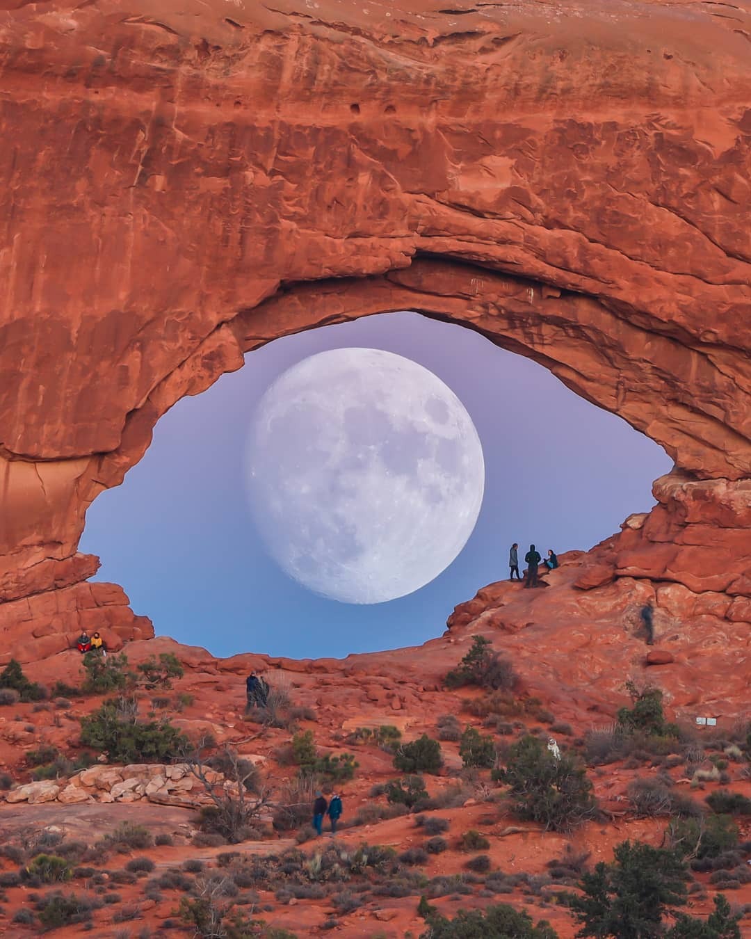 صورا للقمر خلف قوس صخرى تشبه العين بولاية يوتا الأمريكية (1)