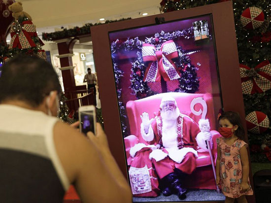 طفلة تلتقط صورة عيد الميلاد مع بابا نويل الافتراضي