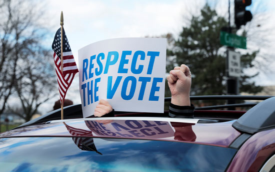 أمريكيون يحملون لافتة مكتوب عليها احترموا نتائج التصويت