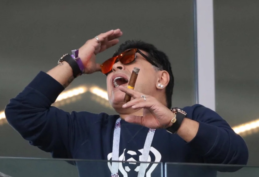 مارادونا يحمل السيجار اثناء مشاهدة لقاء الارجنتين وايسلندا بمونديال 2018