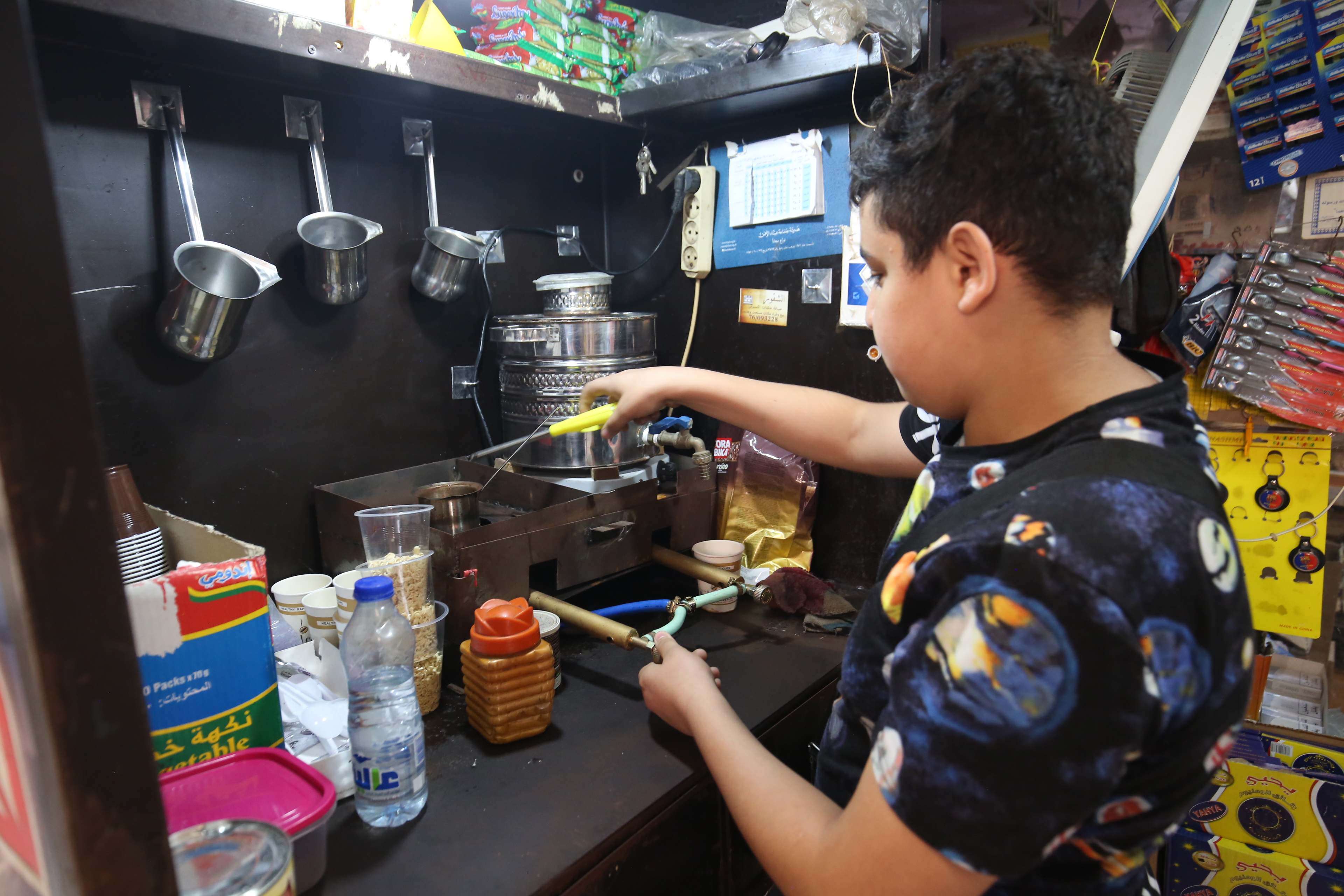 الطفل عماد يجهز القهوة لبيعها