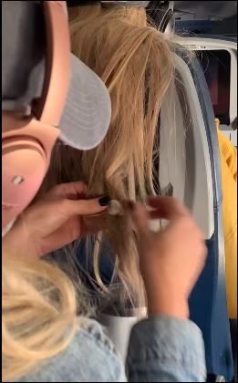 راكبة تضع علكة في شعر آخري على طائرة (1)