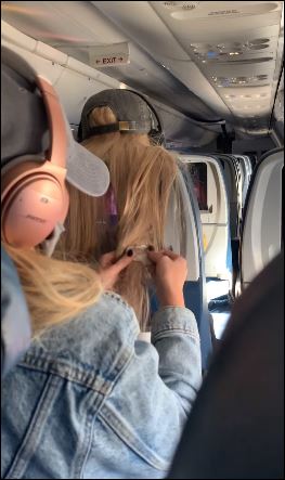 راكبة تضع علكة في شعر آخري على طائرة (2)