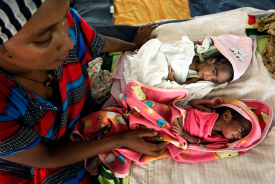 امرأة تهرب بأطفالها من الحرب في إثيوبيا