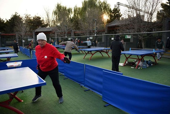 يلعب الناس تنس الطاولة في حديقة في بكين