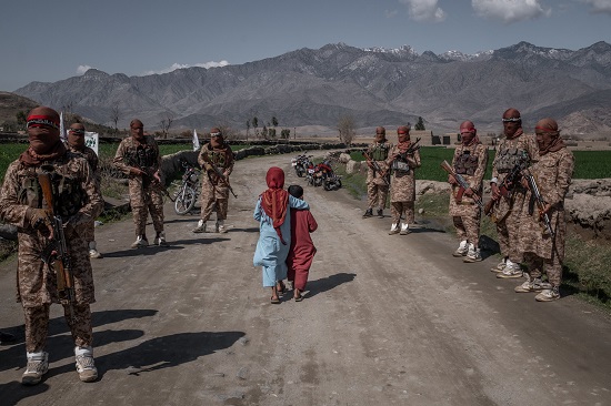 طفلان يسيران أمام أعضاء من وحدة طالبان في أفغانستان