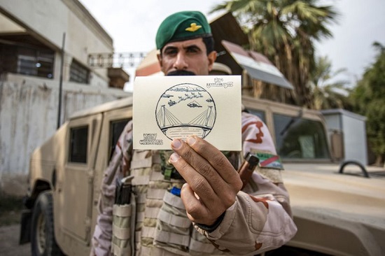 رجل أمن عراقي يحمل بطاقة معايدة