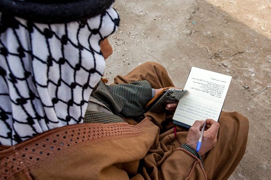 رجل عراقي يكتب بطاقة معايدة