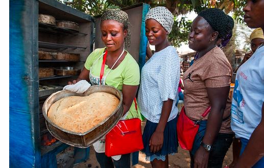 3 نساء يخبزن الخبز في فرن متنقل في مخبز محلي في ليبريا