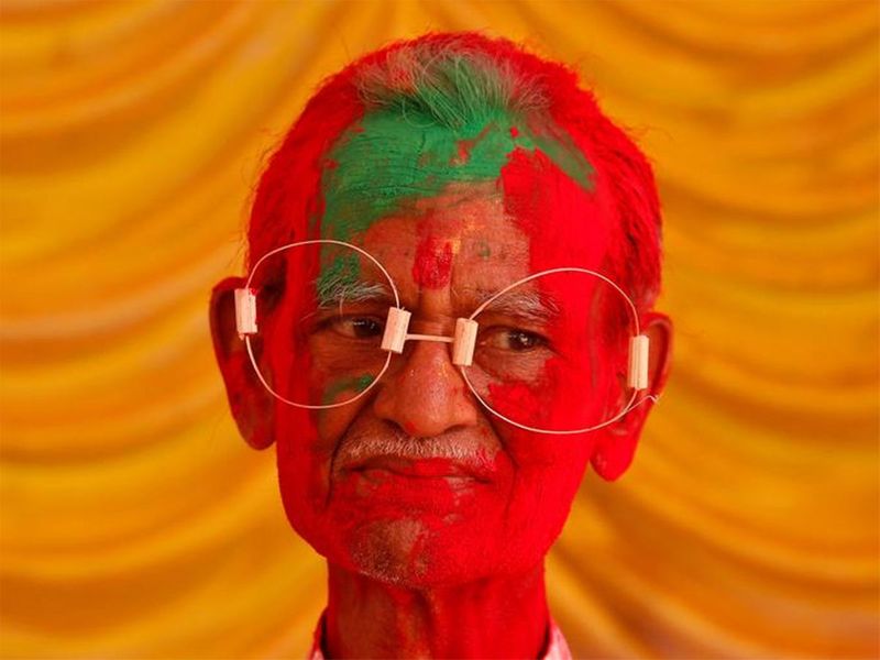 رجل هندي مغطى بالألوان يحتفل بعيد الهولي