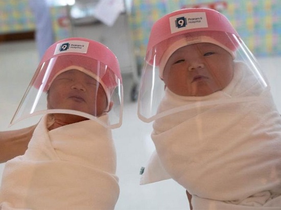 أطفال حديثي الولادة يرتدون دروع واقية للوجه في بانكوك