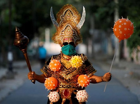هندوسي يرتدي قلادة من البالون على هيئة فيروس كورونا