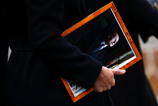 امرأة تحمل صورة الرئيس الفرنسي الراحل